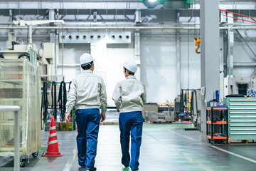 工場で働く作業員グループの後ろ姿