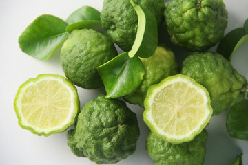 Kaffir lime or bergamot fruit, Kaffir lime or citrus hystrix fruit sliced and decorated with leaves on a white background