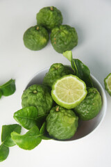 Kaffir lime or bergamot fruit, Kaffir lime or citrus hystrix fruit sliced and decorated with leaves on a white background