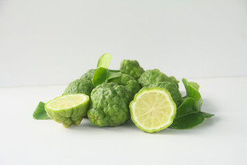 Kaffir lime or bergamot fruit, Kaffir lime or citrus hystrix fruit sliced and decorated with leaves on a white background