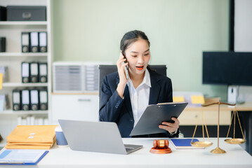 Fototapeta premium young female lawyer handling legal documents at her office desk