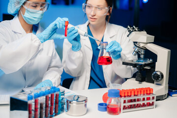 Modern Medical Research Laboratory Portrait of Two Scientists Working, Using Digital Tablet,...
