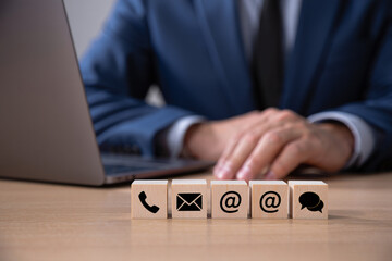 Businessman at Laptop with Contact Us Wooden Blocks Showing Email Phone and Chat