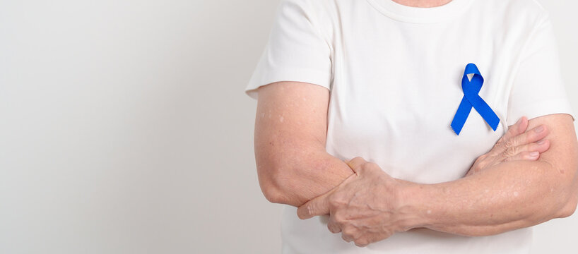 Elderly with dark Blue or Navy blue Ribbon for concept of March Colorectal and Colon Cancer Awareness month, May Arthritis awareness, July Juvenile arthritis and Childhood. Health and world cancer day