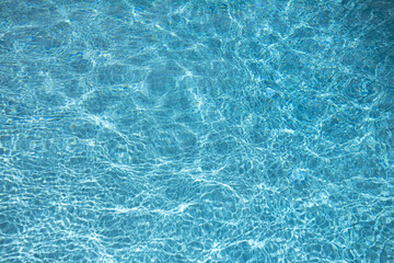 Water view. Transparent water background. Blue pool water texture background. Surface of pool water with ripples.