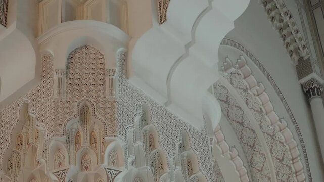 Ornate Moroccan architecture details in Hassan II Mosque, Casablanca. Intricate Islamic art and design showcased on pillars and arches. Stunning visuals of craftsmanship