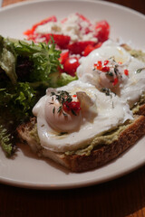 Breakfast with poached eggs and fresh greens on toast