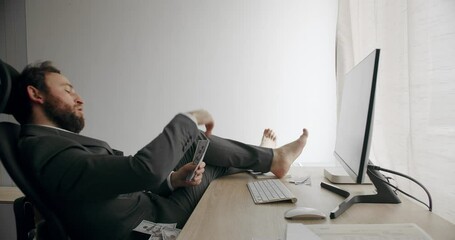 Caucasian man in a suit enjoying his financial success and counting money at office workplace. Concept of salary or profit. Handsome happy businessman scatters the dollars. - Powered by Adobe