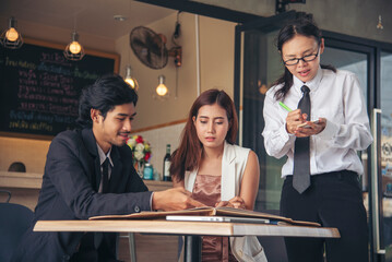 Couple lover order food to waitress in restaurant. Two businesspeople have luch break at coffee shop ordering to Waitress select food from menu happy smile face. Business colleagues lunch break