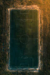 Aerial view of a soccer field surrounded by brown grass, showcasing sports and recreational space.