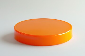 Round, bright orange plastic lid on a plain background.