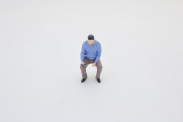 Miniature Figure in Blue Shirt Standing on White Background