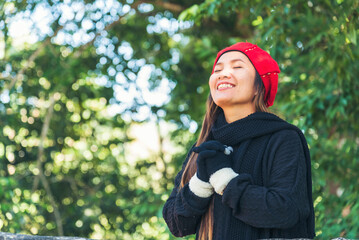Happy Relax beautiful asian woman smiling face standing in green park outdoors garden. Young women...