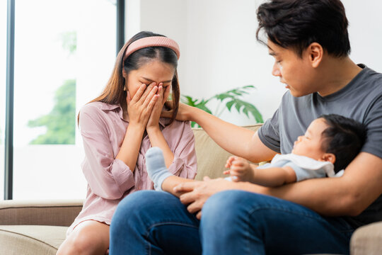 New Mother Crying, Supported by Partner While Holding Baby, Postpartum Depression, Father Comforting Distraught Mother, New Parents Asian Family