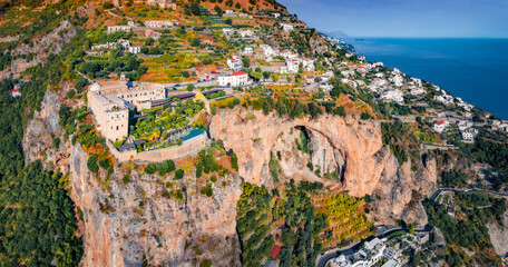 Aerial summer view from flying drone of Santa Maria di Grado drone, located on the huge cliff on Mediterranean coast of Italy, Europe. Traveling concept background.