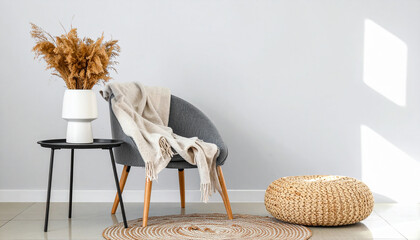 Cozy corner arrangement: This image showcases a serene and inviting interior setting, with a stylish chair, a small table, and decorative elements like a textured pouf, a round rug.