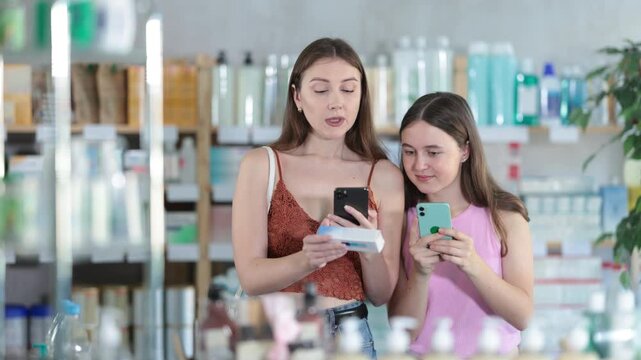 Daughter and mother in summer clothes scans code on ointment to check the expiration date. High quality 4k footage