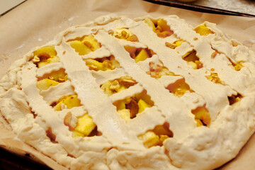 Homemade apple pie, on a baking sheet, ready to go into the oven.