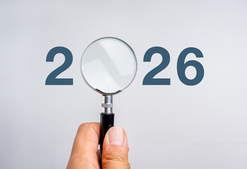 Happy new year 2026, business goal plan and trends concept banner. 2026 year calendar number, with empty blank space for advertising or ideas inside magnifying glass lens, isolated on blue background.