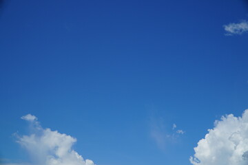 Clear blue sky with fluffy white clouds scattered throughout the expanse.