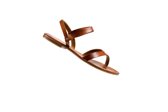 A tan sandal with a strap is shown in the air