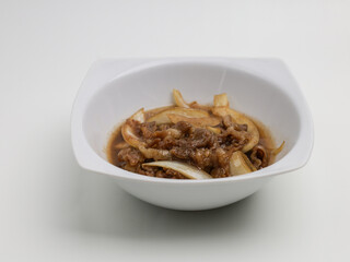 Stir fries meat and onion with sweet sauce on white plate