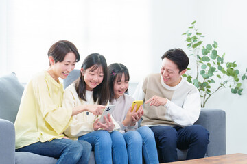 リビングでスマートフォンを使う親子