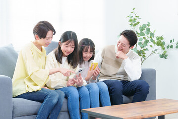リビングでスマートフォンを使う親子