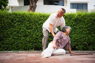 Senior Man Helping Fallen Woman Outdoors, Concerned Husband Assistant Wife Who Has Fallen on Pavement, Elderly Asian Couple Facing a Medical Emergency Outside Their Home