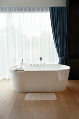 bathtub near a window with curtain