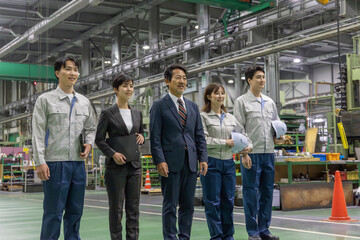  工場で並んで立つ作業スタッフのグループ