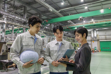  工場を視察する女性ビジネスパーソンと男性作業員