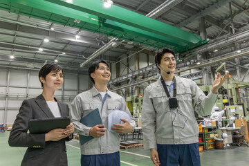  工場を視察する女性ビジネスパーソンと男性作業員