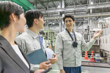  工場を視察する女性ビジネスパーソンと男性作業員