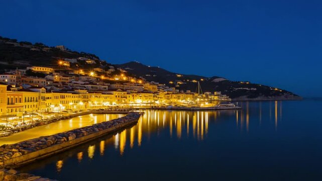 A charming coastal town illuminated at night with warm lights reflecting on calm water, symbolizing European charm and serene nightlife. Ideal for travel vlogs or romantic content.
