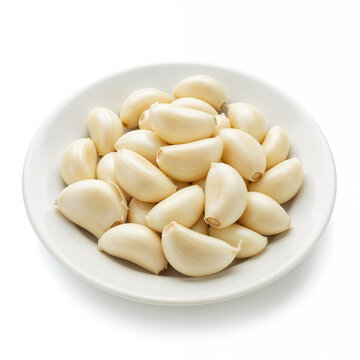 Fresh garlic cloves sit peeled on a white plate ready for cooking use