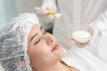 Beautiful woman receive spa and treatment skin of face. face of a healthy woman apply cream....