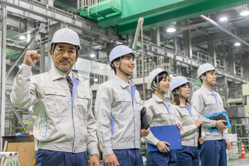 工場の中でガッツポーズする作業員