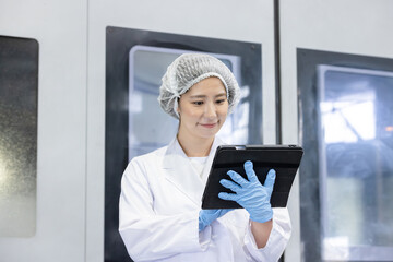 工場でタブレットを持って仕事をする作業員