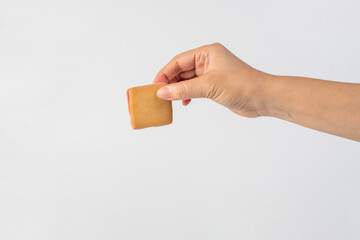 Square crispy snack in hand on white background