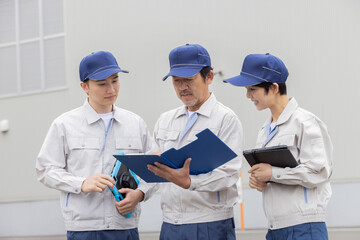 屋外でミーティングする作業員グループ