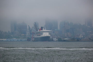 Luxury ocean liner cruiseship cruise ship Queen Mary docked at terminal in Brooklyn on grey rainy...