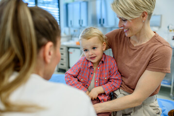 Pediatrician examing little boy during preventive health check up.