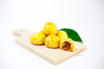 Nastar cookies are neatly arranged on a cutting board and shiny, filled with lots of pineapple jam, isolated on a white background.
