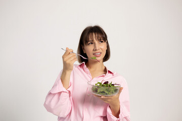 Woman with salad bowl isolated on white. Female holding asparagus wrapped in measuring tape, taking...