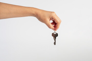 Key with a ring in hand on a white background.