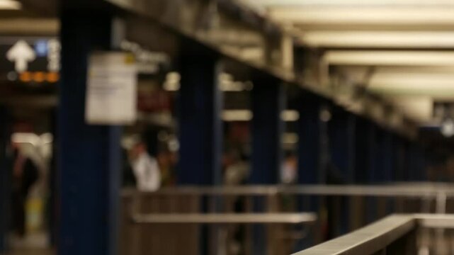 New York City, Manhattan. Defocused subway station interior, underground metropolitan transfer. Public metro transport. Railway change hub, passenger traffic junction. People in NYC, United States.