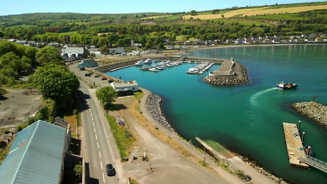 Advancing aerial video of Glenarm Bay, on the Causeway Coastal Route in Northern Ireland, on a bright and sunny day. Filmed in 4K, 60FPS and with Rec709 color.