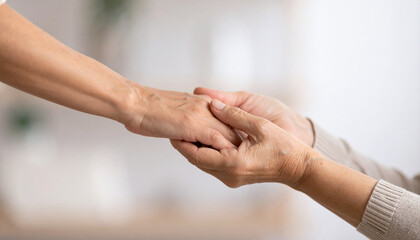 Fototapeta premium a close up shows one hand holding another, creating a sense of comfort and support. the younger hand is extended outward, while the other hand gently covers it, enveloping it in a warm embrace