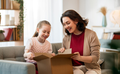 Mother and daughter are unpacking cardboard